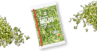 Zak gesneden andijvie van Albert Heijn, omringd door losse stukjes andijvie