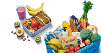 Albert Heijn boodschappenmand met verse producten zoals broccoli, wortels, tomaten, bananen, brood, croissants, appelsap, melk, en een lunchbox gevuld met boterhammen, fruit, noten en een smoothie