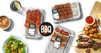 Barbecue vleesproducten en salade op tafel, met dipsaus en een drankje.