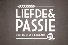 Logo van Albert Heijn met de tekst "Liefde & Passie" en de slagzin "Rustiek, vers & krokant" op een bruine achtergrond.