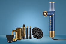 Blauw en gouden multistyler föhn met verschillende opzetstukken op een blauwe achtergrond