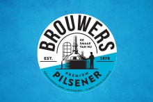 Rond logo van Brouwers Premium Pilsener bier op blauwe achtergrond, met afbeelding van brouwer en bierketel.