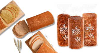 Drie verpakkingen AH Bakkers Brood tijgerbrood en verschillende gesneden plakken tijgerbrood op een houten plank, met tarwe oren ter decoratie.