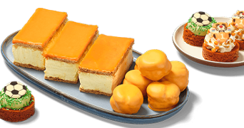 Taartjes en gebakjes met oranje glazuur en voetbaldecoraties op een schaal, perfect voor feestelijke gelegenheden zoals Koningsdag of het EK voetbal.