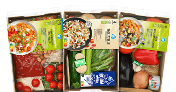 Drie AH maaltijdboxen met ingrediënten voor verschillende Italiaanse gerechten, waaronder groenten, kaas, saus en pasta, in kartonnen verpakkingen met maaltijdkaarten.