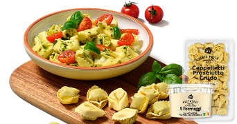 Schaal met cappelletti pasta, verse basilicum, cherrytomaatjes, en producten van Albert Heijn: cappelletti prosciutto crudo en pastasaus 5 formaggi.