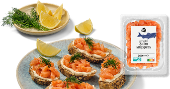 Gerookte zalmsnippers van Albert Heijn, geserveerd op brood met dille en citroenpartjes.