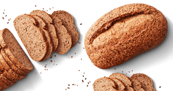 Volkorenbrood, deels gesneden en deels als hele brood, op een zwarte achtergrond.
