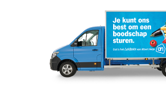 Blauwe Albert Heijn bestelwagen met reclamebord waarop staat: "Je kunt ons best om een boodschap sturen. Dat is het lekkere van Albert Heijn." met afbeeldingen van boodschappen.