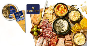 Borrelplank met diverse AH Excellent hapjes, zoals kazen, vleeswaren, patés, dips en olijven, gepresenteerd op een houten plank.