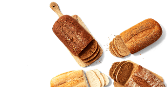 Verschillende soorten gesneden broden op een plank en op tafel, waaronder donker meergranenbrood, witbrood en volkorenbrood