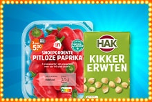 Bakje Albert Heijn snoepgroente pitloze paprika’s en blik HAK kikkererwten op een blauwe achtergrond.