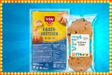 Twee verpakte glutenvrije broodproducten, waaronder Schär Kaiserbrötchen en een verpakt AH Vrij koekje, tegen een blauwe achtergrond met lichtjesrand.