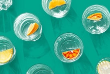 Glazen met stukjes citrusfruit op een turquoise ondergrond