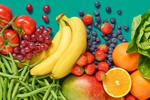 Verscheidenheid aan verse groenten en fruit, waaronder bananen, tomaten, druiven, aardbeien, blauwe bessen, sinaasappels, mango, sperziebonen en sla, op een groene achtergrond.