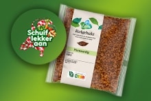 Verpakking van AH plantaardige kruimgehakt naast een sticker met de tekst "Schuif lekker aan" op een groene achtergrond.