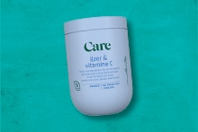 Care IJzer & Vitamine C supplement op een turquoise achtergrond