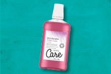 Mondwaterfles van het merk Zendium Care tegen een blauwe achtergrond.