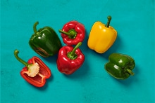 Verschillende kleurrijke paprika's op een blauwe achtergrond.