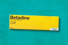 Betadine zalf verpakking op een groene achtergrond