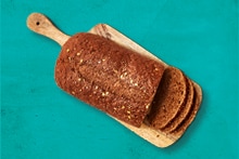 Gesneden volkorenbrood op een houten snijplank.