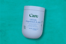 Care calcium, magnesium en zink supplement op een turquoise achtergrond.