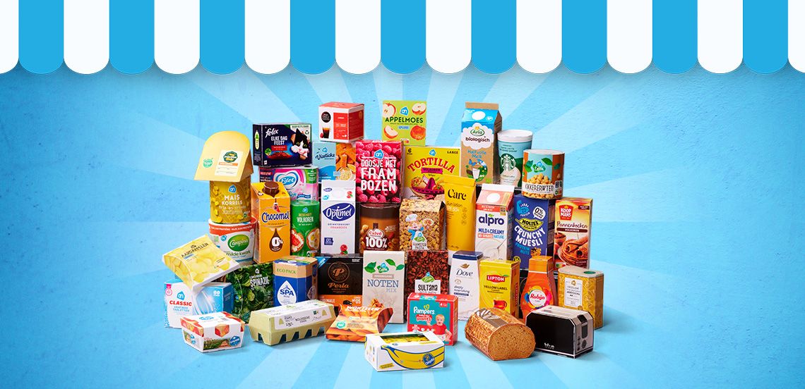 Verschillende boodschappenproducten van A-merken en huismerken van Albert Heijn, waaronder ontbijtgranen, zuivel, sap, brood, pasta, snacks en schoonmaakmiddelen, uitgestald op een blauwe achtergrond met winkeldakje.