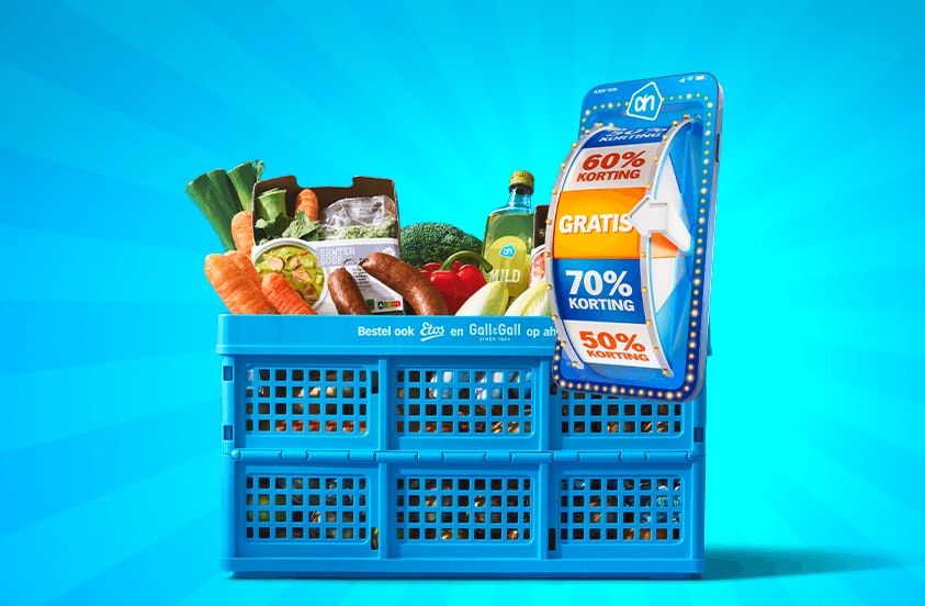 Blauwe Albert Heijn krat gevuld met boodschappen en een actiekaart met kortingen tot 70% en gratis aanbiedingen, op een blauwe achtergrond.