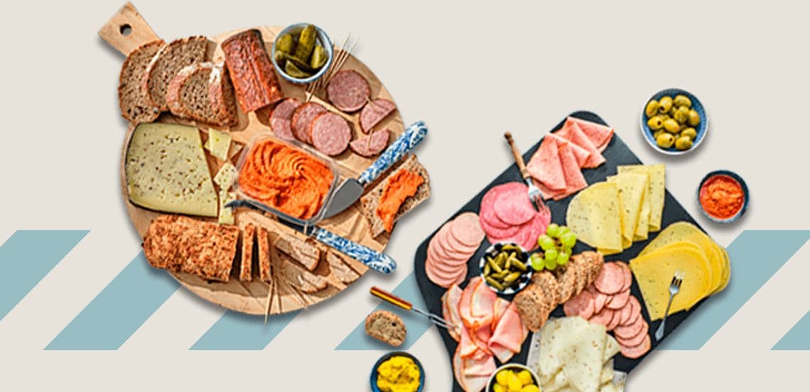 Borrelplanken met verschillende soorten kaas, vleeswaren, brood, augurken, olijven en dips
