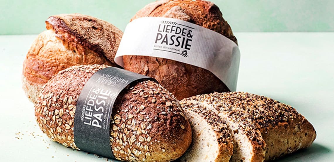 Verschillende broden uit het Liefde & Passie assortiment van Albert Heijn, waaronder een meergranenbrood met zaden, een robuust desembrood en een deels gesneden brood.