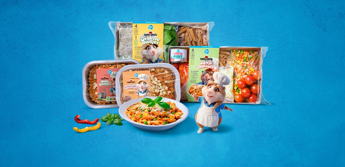 Een selectie van Albert Heijn verse maaltijdpakketten, pastagerechten en groentes op een blauwe achtergrond, met een cartoonfiguur van een hamster als kok erbij afgebeeld.