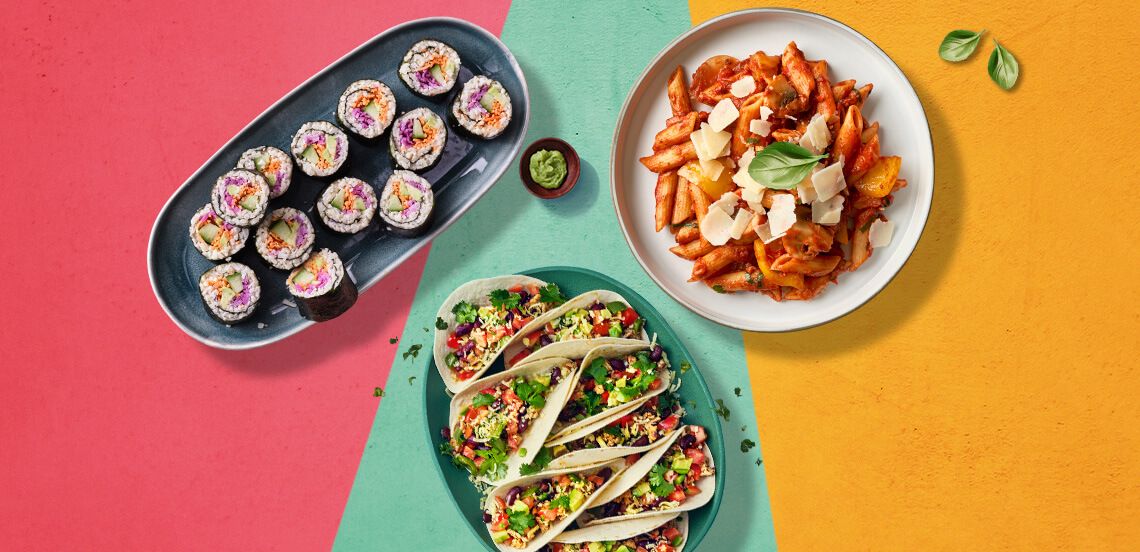Assortiment van wereldkeuken gerechten met sushi, pasta en gevulde taco’s op kleurrijke achtergrond