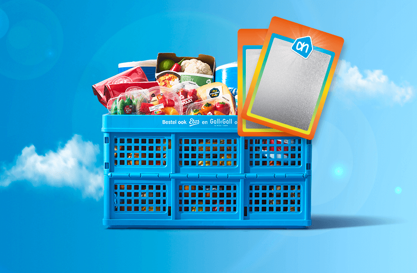 Blauwe Albert Heijn krat gevuld met boodschappen en twee AH verzamelkaarten op een blauwe achtergrond