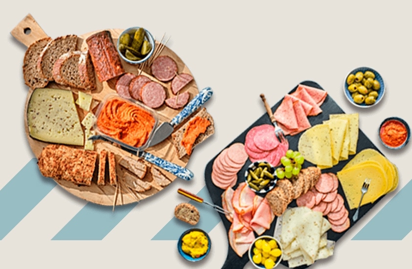 Borrelplanken met verschillende soorten kaas, vleeswaren, brood, augurken, olijven en dips
