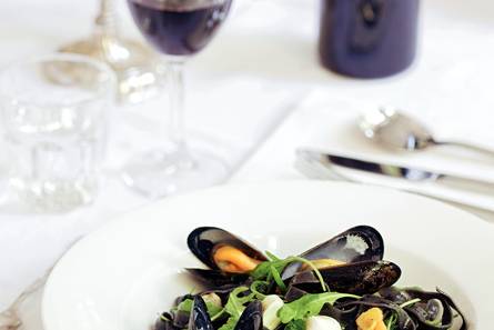 Zwarte tagliatelle met mosselen in de schelp