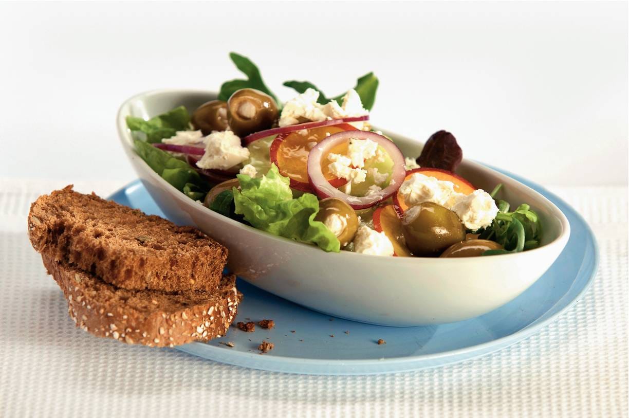 Gemengde salade met witte kaas, olijven en nectarine
