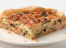 De roomkaas met knoflook en kruiden geeft deze quiche een zachte smaak.