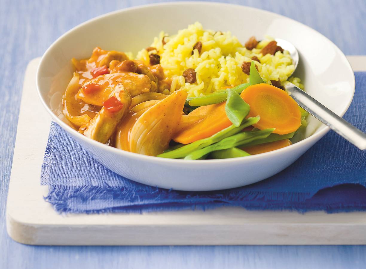 Milde kipcurry met gele rozijnenrijst