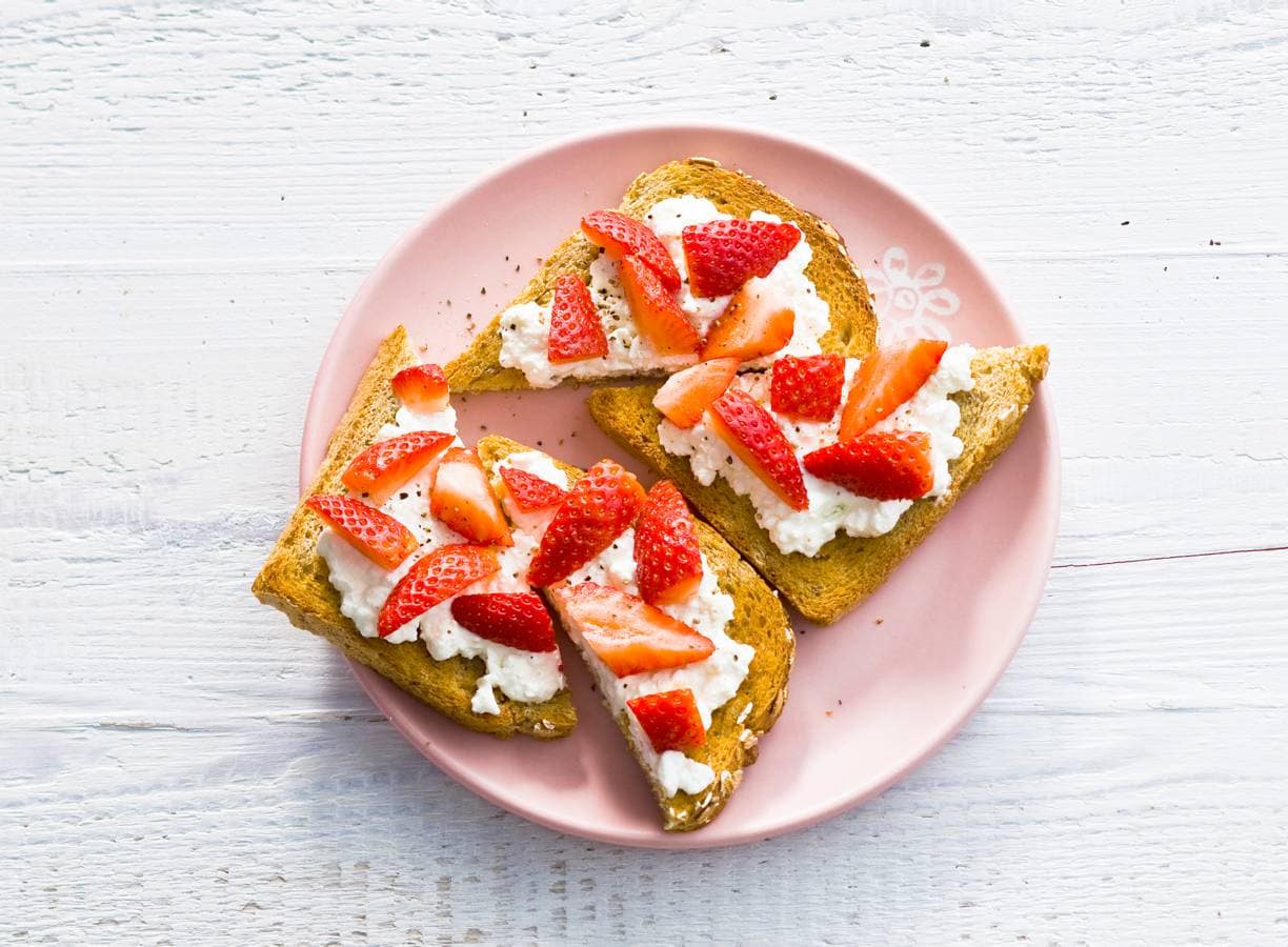 Volkorentoast met hüttenkäse, aardbei en peper