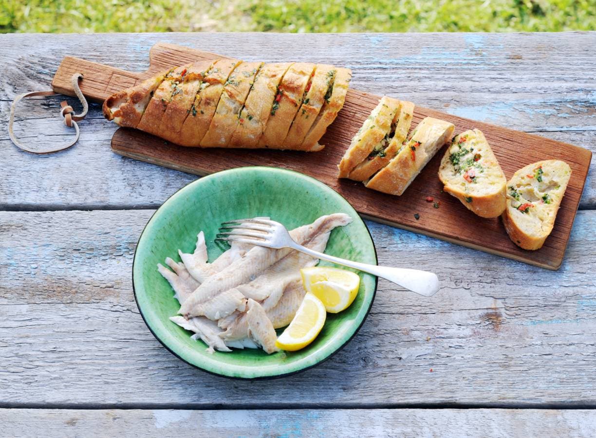 Forel in krant met barbecuestokbrood