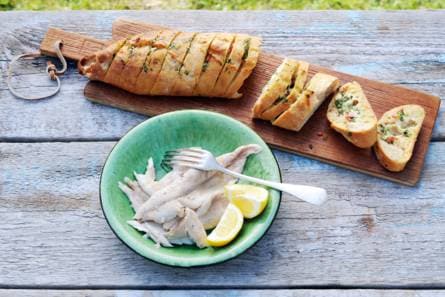 Forel in krant met barbecuestokbrood