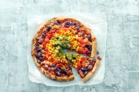 Pizza met regenboog van groenten