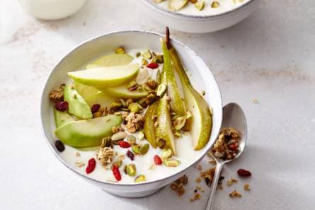 Sojayoghurt ontbijt met pistachenoten, appel, peer, limoen, avocado en granola.