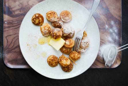 Poffertjes met kaneel, boter en poedersuiker