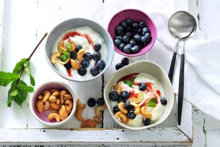Griek­se yog­hurt met cas­hew­no­ten, blau­we bes­sen en aard­bei­en­s­wirl