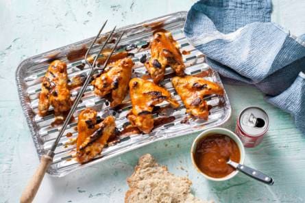 Sticky kip en cola van een wegwerpbarbecue