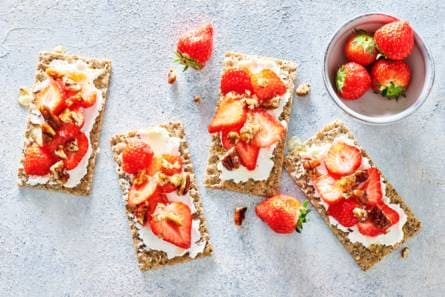 Knäckebröd met geitenkaas, aardbeien en gekaramelliseerde pecannoten