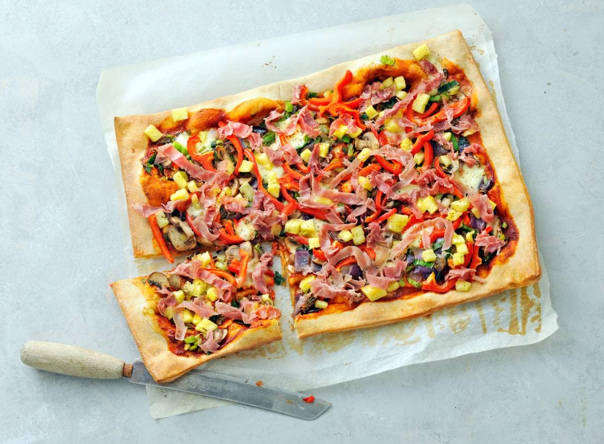 Volkorenpizza met groenten, parmaham en ananas