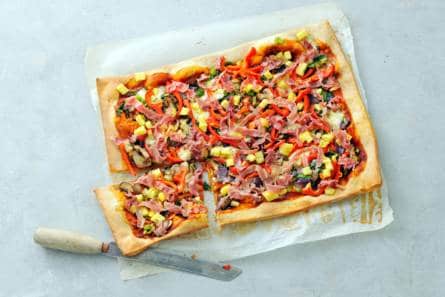 Volkorenpizza met groenten, parmaham en ananas