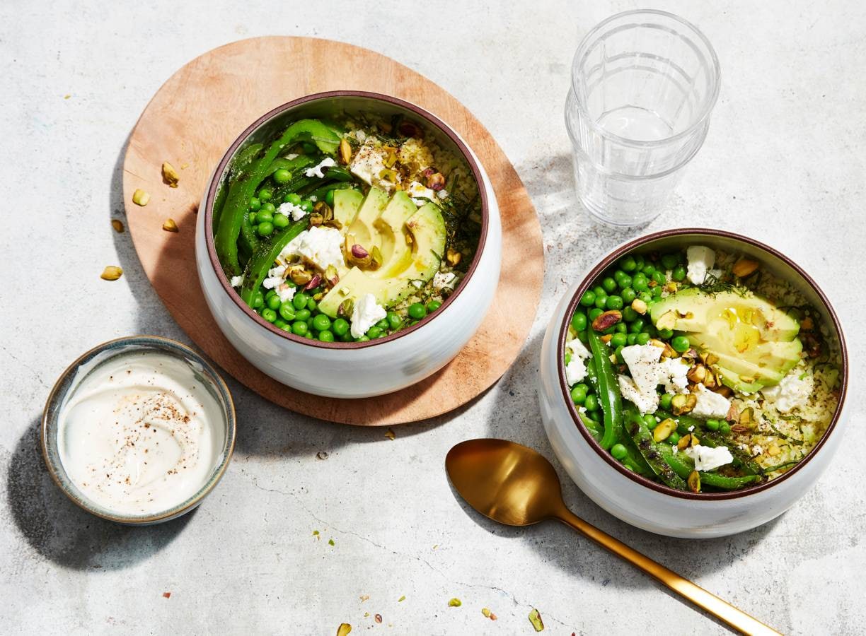 Groene bowl van broccolirijst met avocado en pistache
